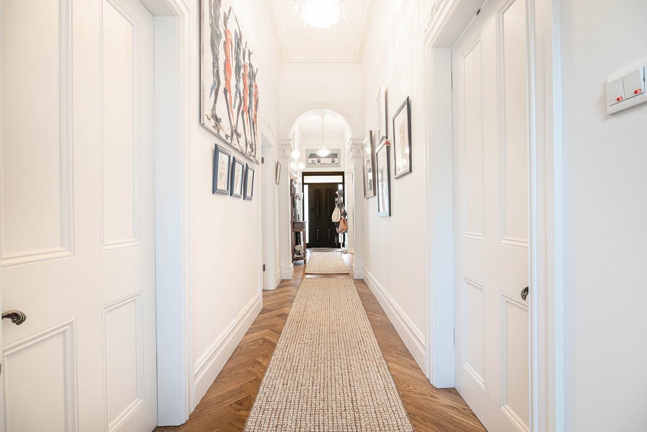 our-experience Bright modern hallway in Melbourne home with contemporary artwork and stylish interior design.